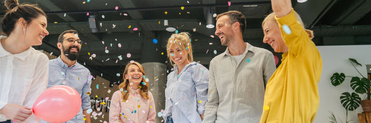 Group of executives celebrating boosted productivity from their wellness program implementation.