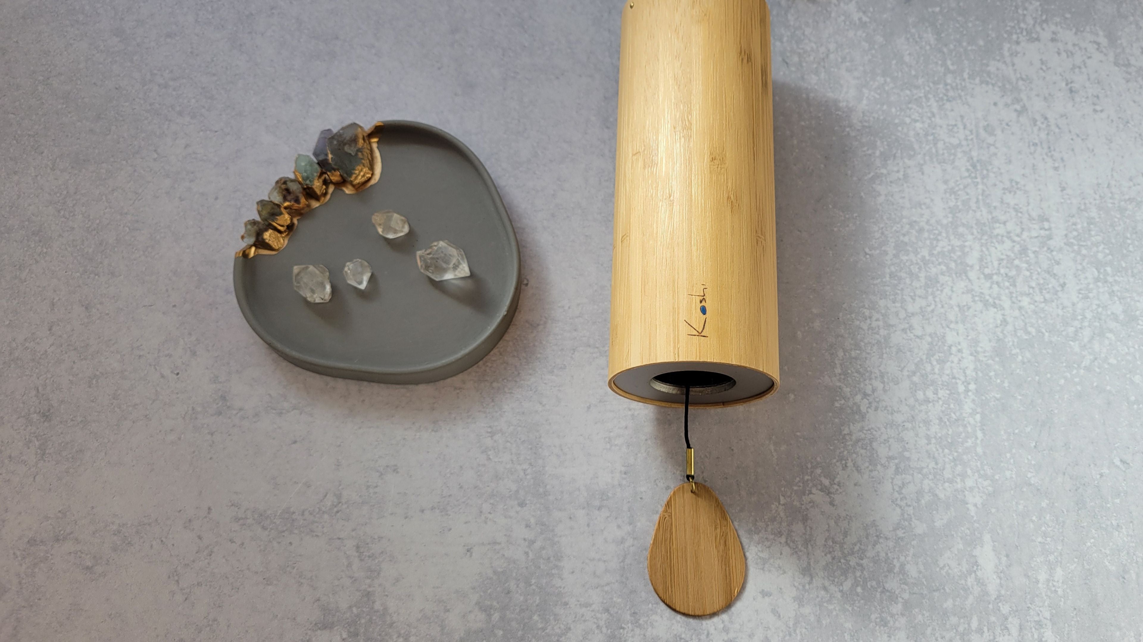Serene image of koshi sound chime and crystals on cement background