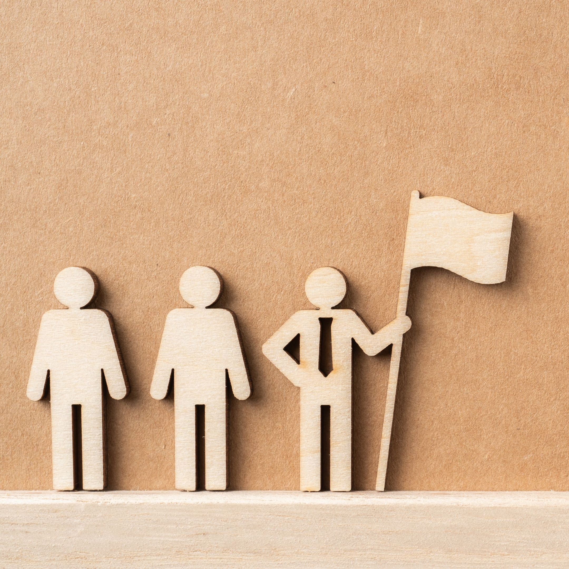 Picture of wood art carving designs of business people holding a victorious achievement flag