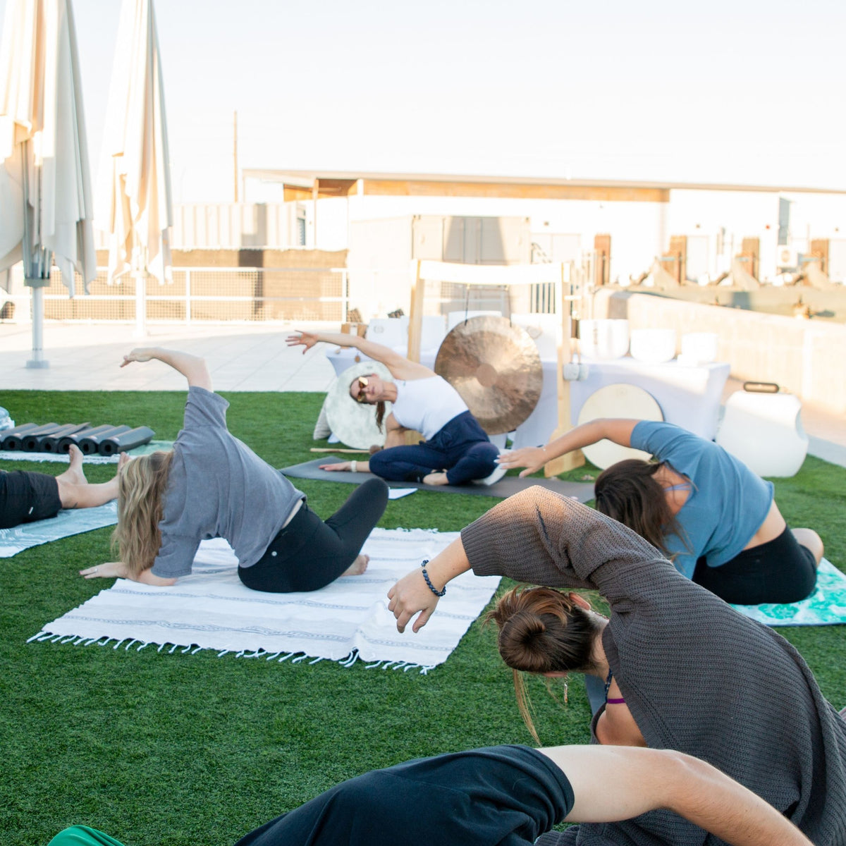 Liz Adriano, Ascendify Wellness™ founder, facilitating an Arizona Team Building Activity outdoors on a grassy area with a building in the background.