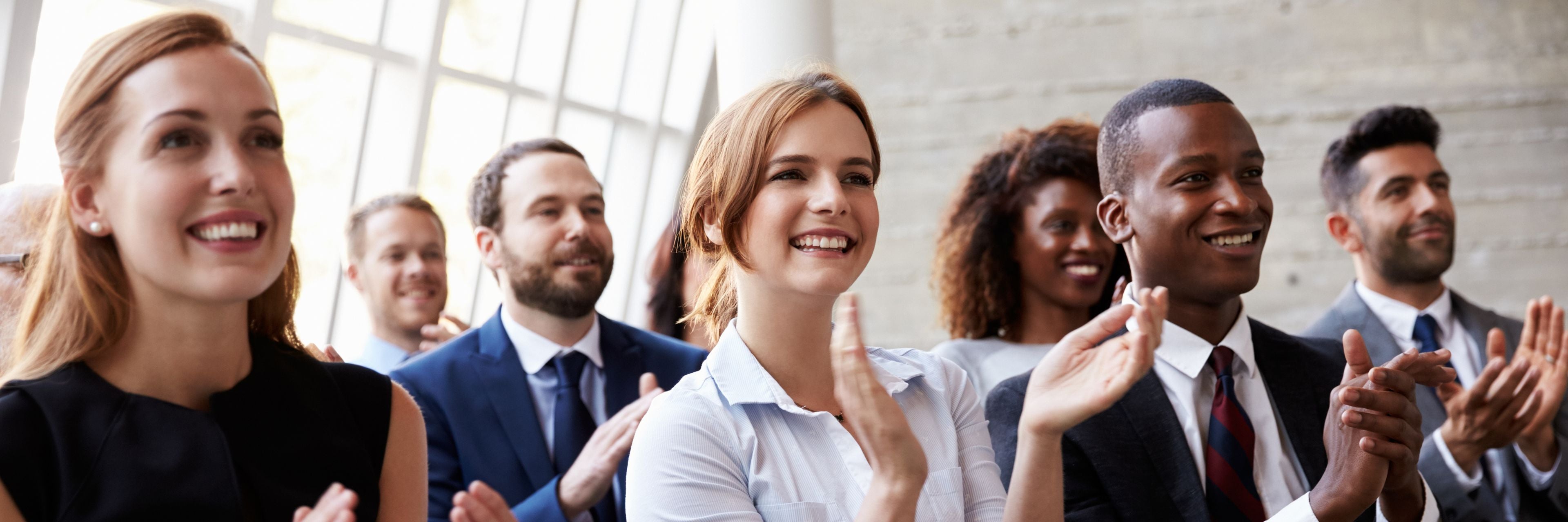 Group of professionals clapping in a well-lit room