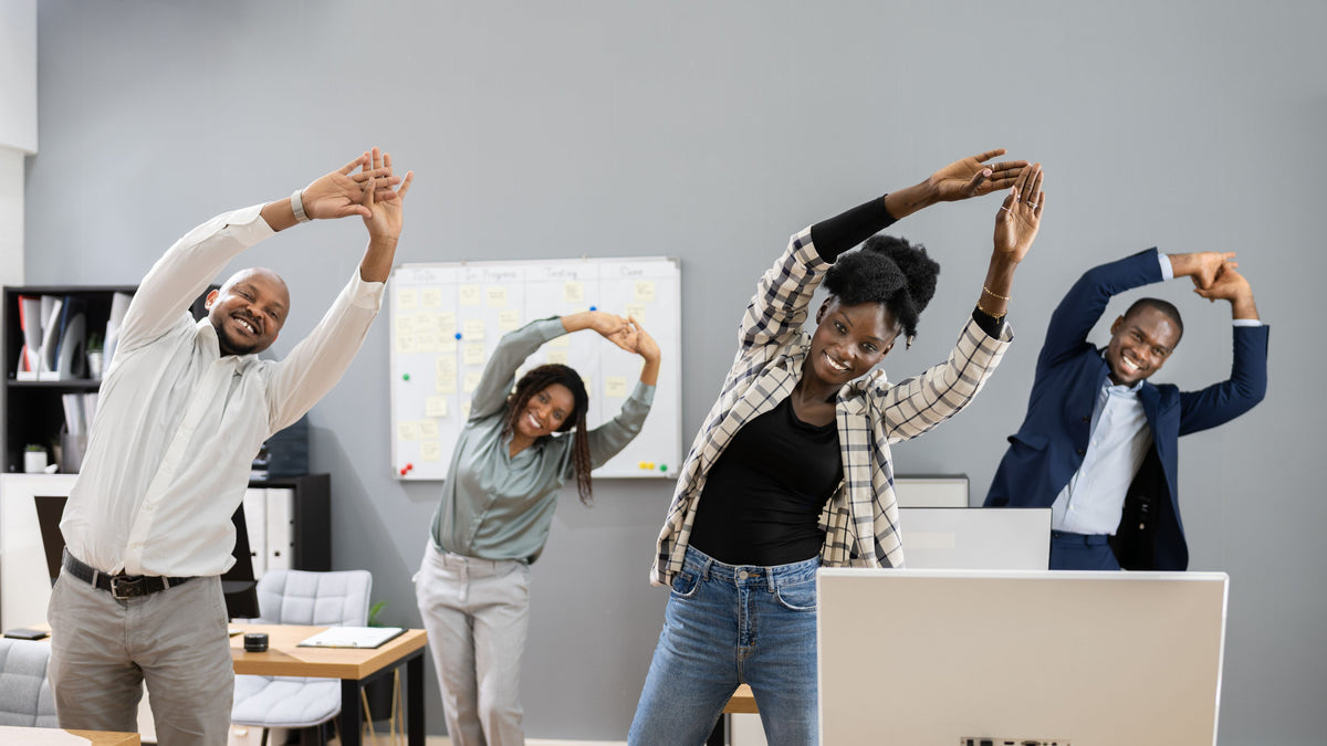 Group of leaders stretching in a team building activity in a modern office setting