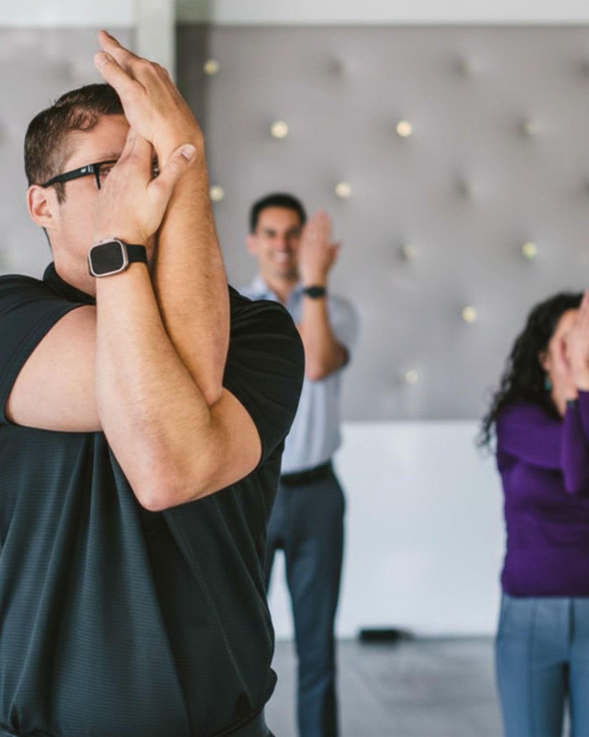 Three people participating in a Colorado Ascendify Wellness Attendee Attention Reset experience indoors at an event venue.