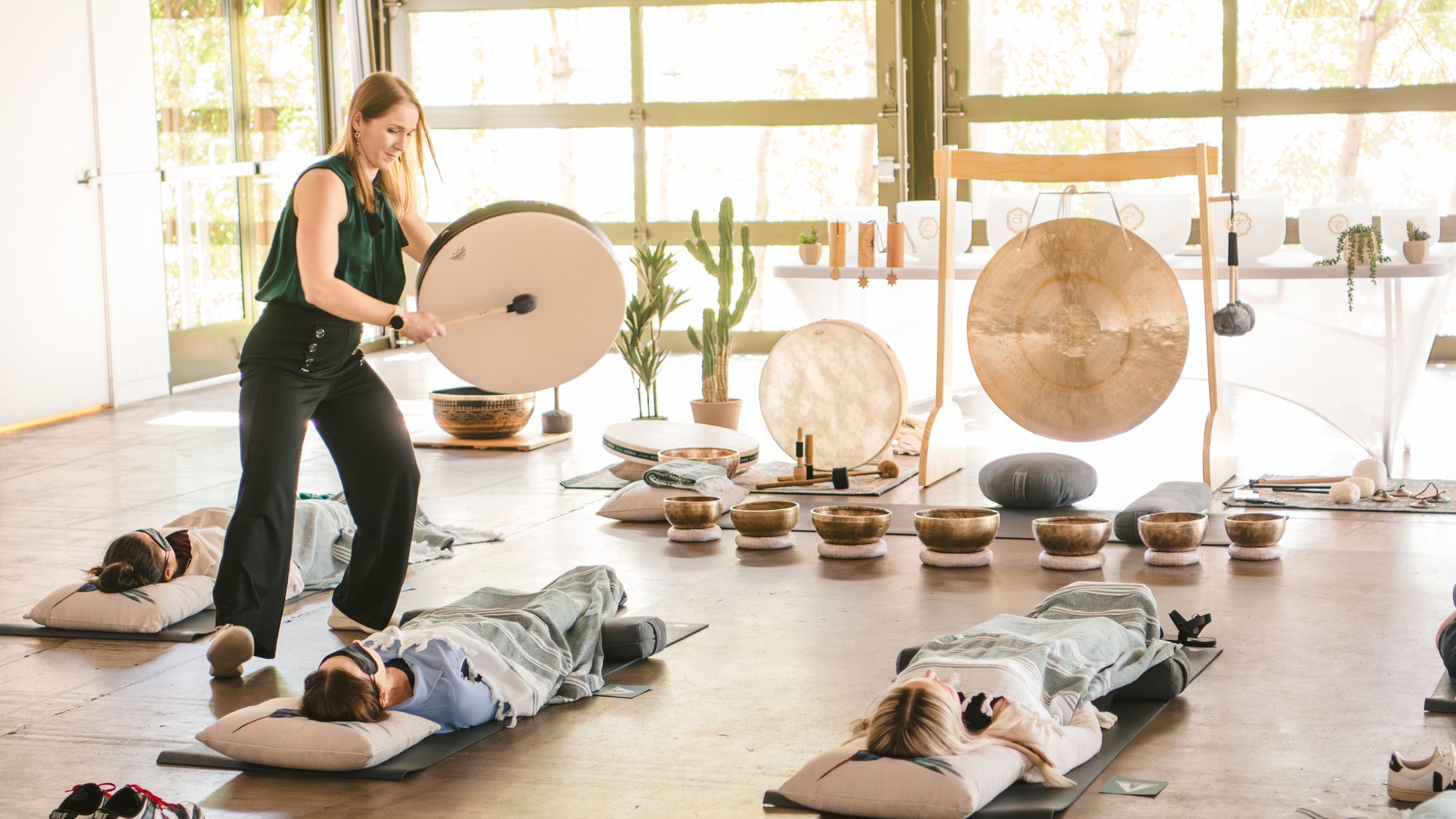 Group of executives lying on Ascendify Wellness comfort kits with Liz Adriano facilitating an effortless guided meditation with precision instruments.
