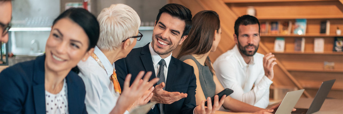 Group of leaders and executives in a meeting room engaged in a team building activity discussion.