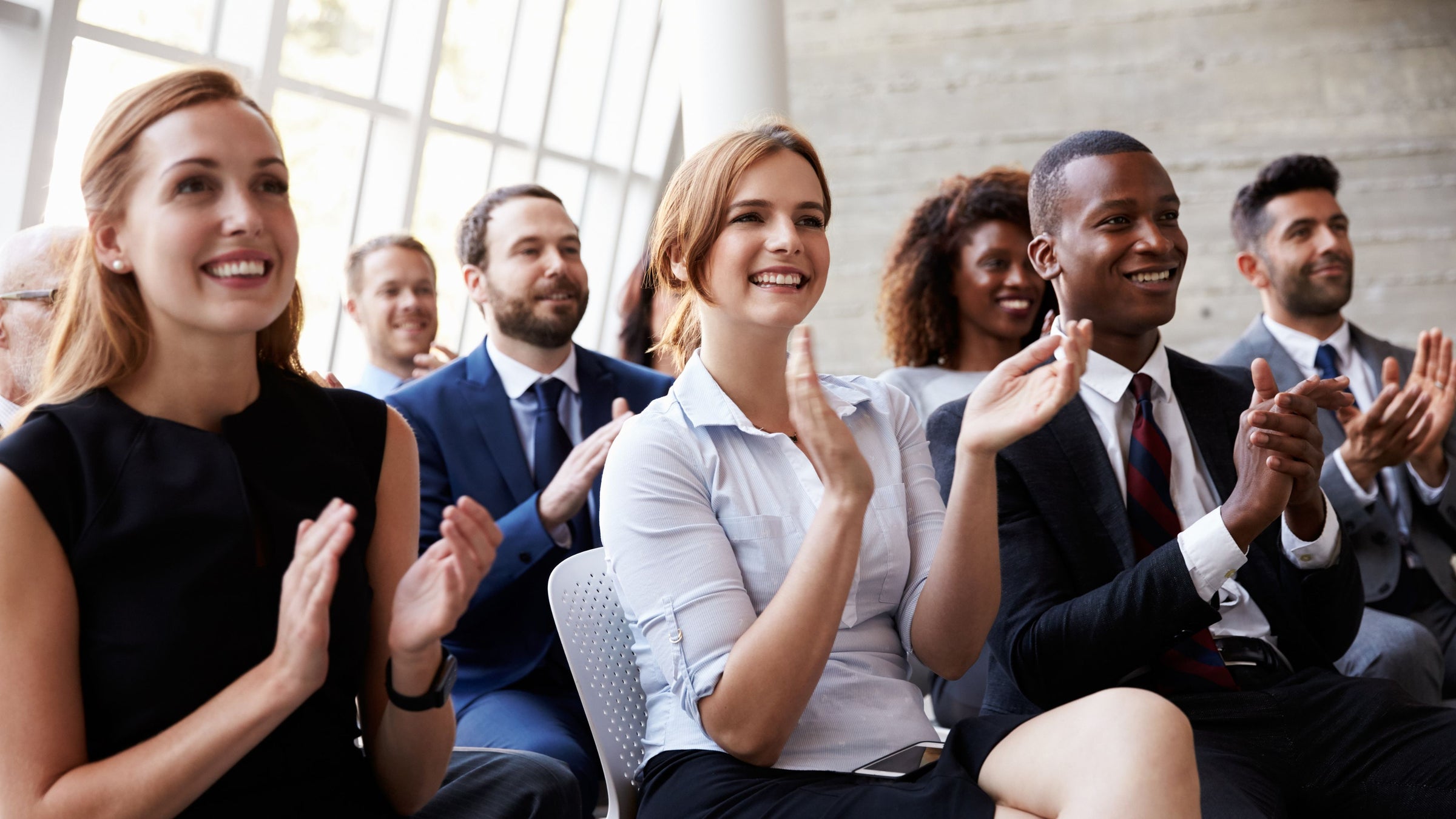Group of professionals clapping after a keynote presentation.