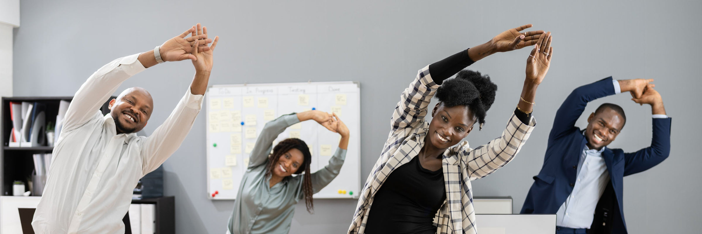 Group of leaders stretching in a team building activity in a modern office setting